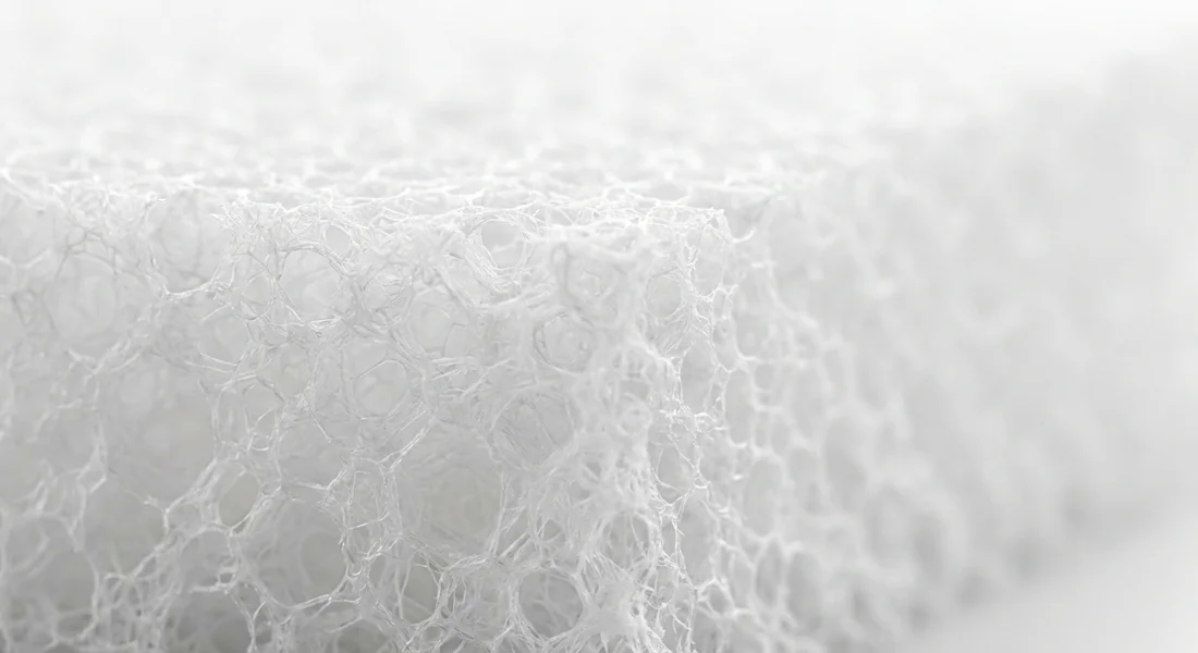 Vue rapprochée de la structure alvéolaire d'une éponge en mousse de mélamine.